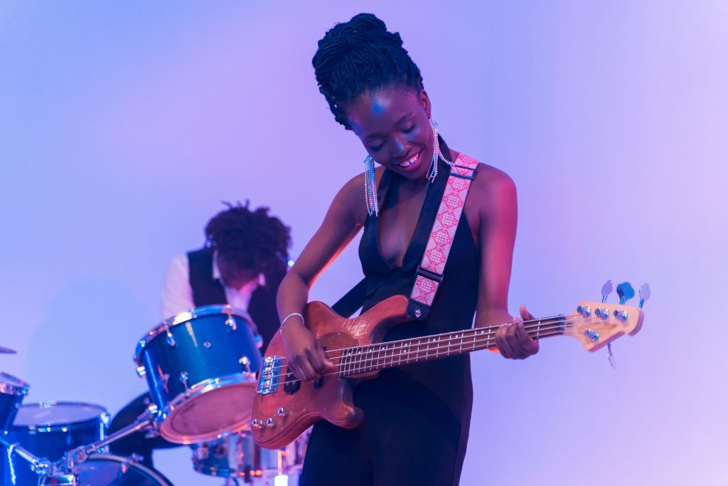 black woman playing bass guitar