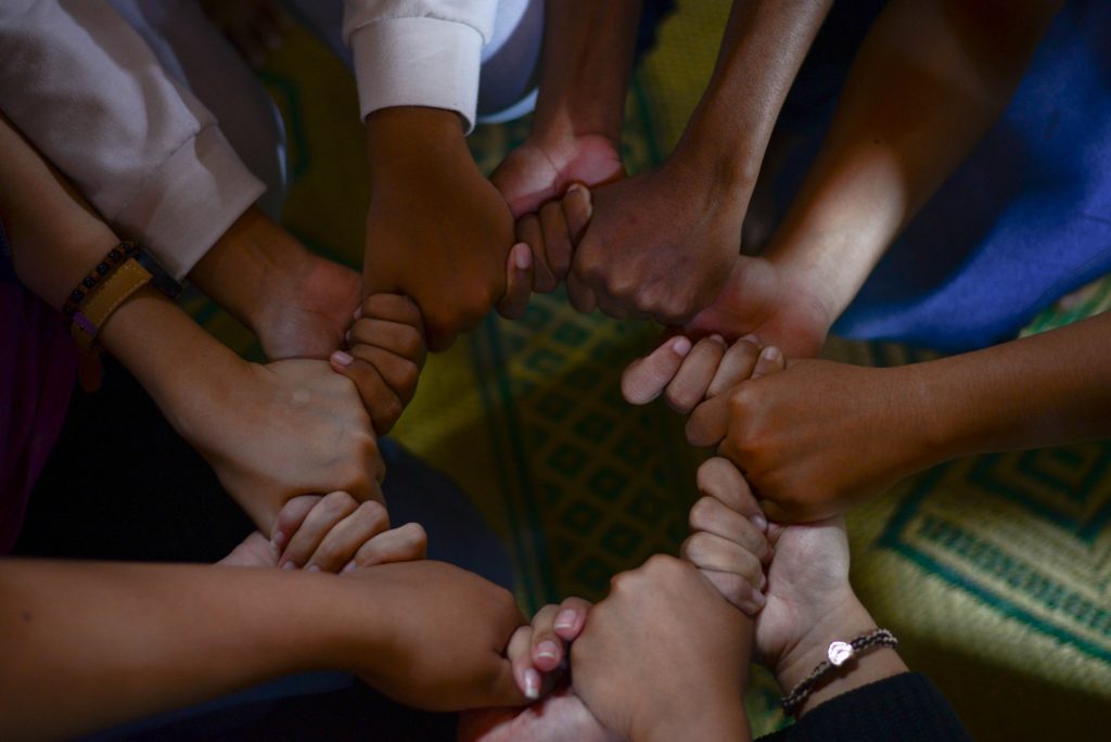 a group of peoples hands coming together